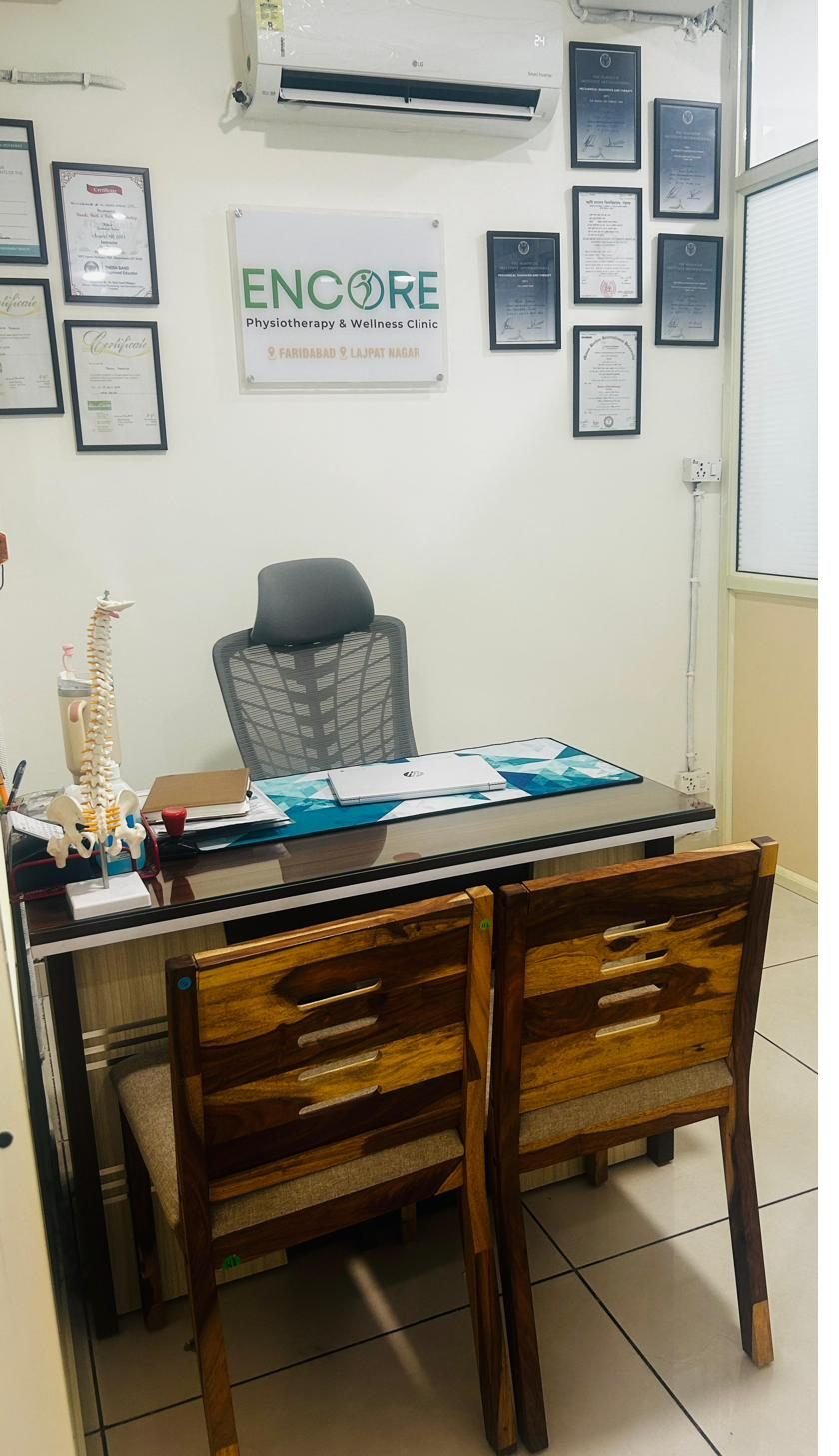 Encore consultation room with spine model and certifications
